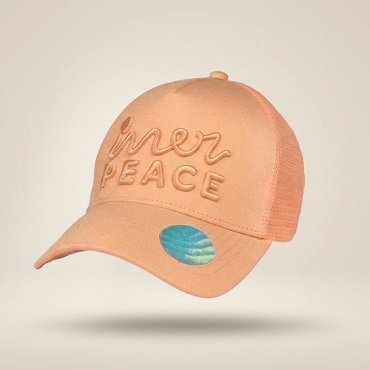 A peach-colored trucker cap with 'mer PEACE' embroidered on the front, set against a light beige background.